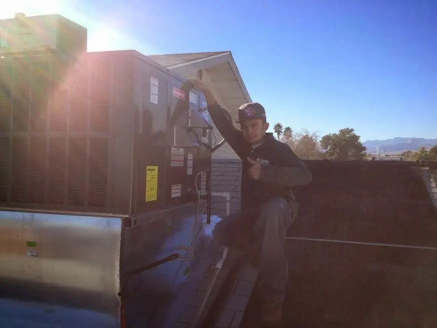 HVAC technician performing AC Tune-Up on a rooftop unit in Key West
